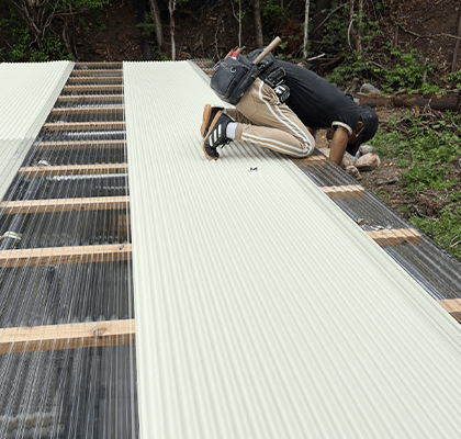 職人が屋根の板金材を丁寧に施工している様子