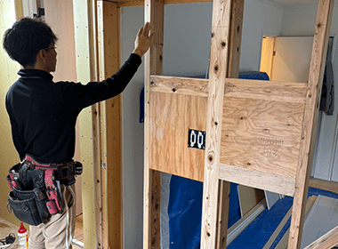 壁の下地を確認しながら施工する作業員の様子